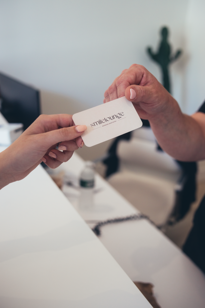 Handing over SMILELOUNGE business card in Brooklyn, NY dental clinic